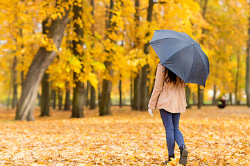 Image showing young woman with umbrella in autumn park