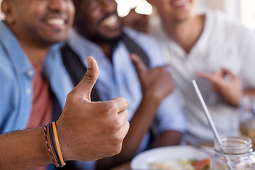 Image showing close up of male friends showing thumbs up at bar