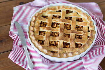Image showing close up of apple pie in baking mold and knife