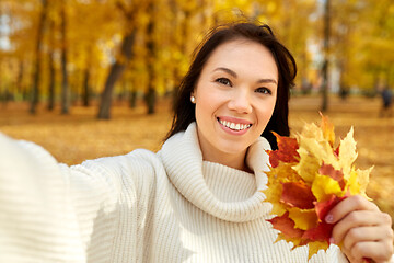 Image showing woman with leaves taking selfie in autumn park