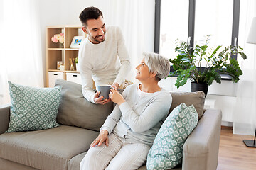 Image showing adult son bringing coffee to senior mother at home