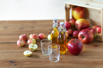 Image showing glasses and bottles of apple juice on wooden table