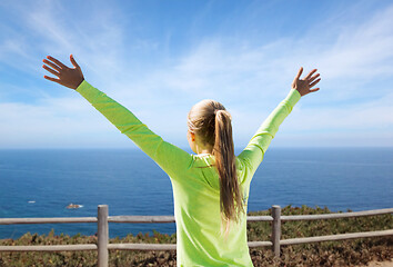 Image showing happy woman in sports clothes over sea background