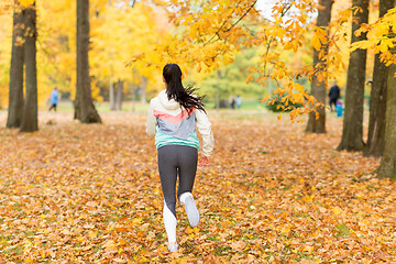 Image showing young woman running in autumn park