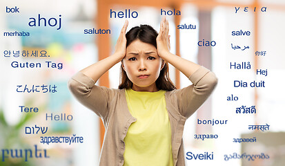 Image showing stressed asian woman over foreign words