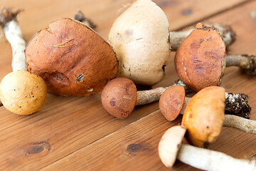 Image showing brown cap boletus mushrooms on wooden background