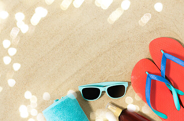 Image showing straw hat, flip flops and sunglasses on beach sand