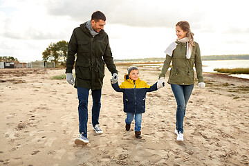 Image showing happy family walking along autumn beach