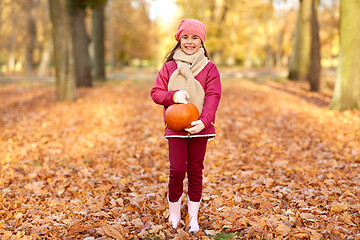 Image showing happy girl with pumpkin at autumn park