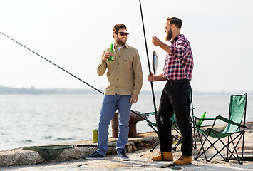 Image showing male friends with fishing rods and beer on pier