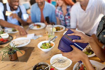 Image showing female hands holding wallet at restaurant