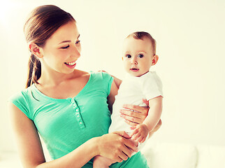 Image showing happy young mother with little baby at home