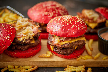 Image showing A set of red bun homemade delicious burgers of beef, bacon, cheese, grilled onion on a dark rusty