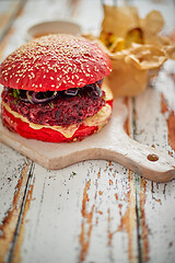 Image showing Homemade vegetable beetroot burgers. Red colored sesame bun. Served with goat cheese, feta