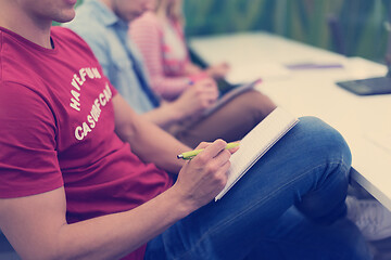 Image showing male student taking notes in classroom