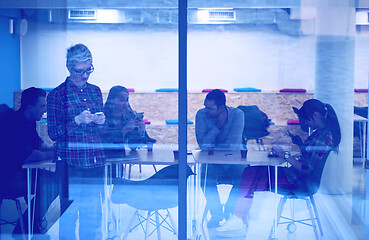 Image showing business woman at office speaking by phone  team on meeting in b