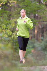 Image showing Pretty young girl runner in the forest.