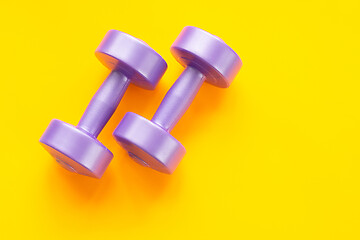 Image showing Two purple dumbbells on a yellow background