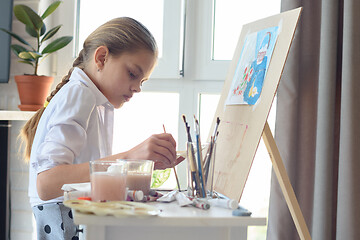 Image showing Young artist draws in the studio behind an easel