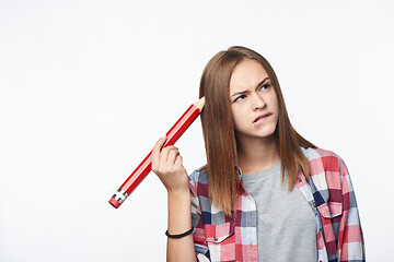 Image showing Contemplating girl scratching her head with big pencil