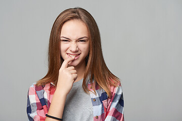 Image showing Dubious teen girl thinking biting her finger