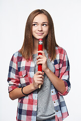 Image showing Smiling girl holding big pencil and looking to the side