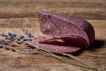 Image showing Lavender cheese with twigs of fresh lavender flowers on rough wooden planks