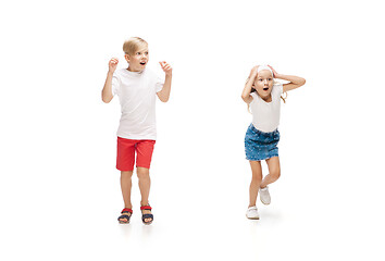 Image showing Happy little caucasian girl and boy jumping and running isolated on white background