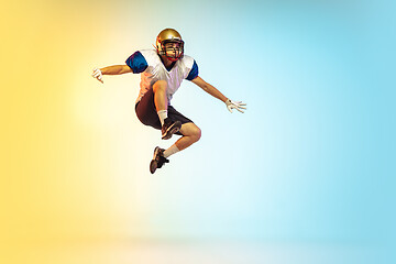 Image showing American football player isolated on gradient studio background in neon light