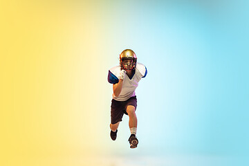 Image showing American football player isolated on gradient studio background in neon light