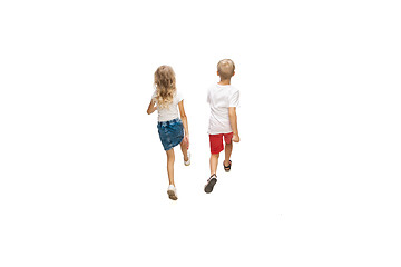 Image showing Happy little caucasian girl and boy jumping and running isolated on white background