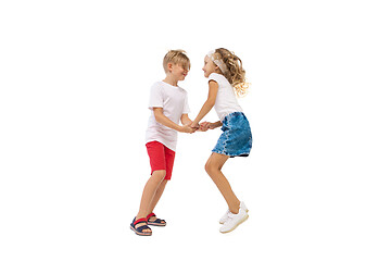 Image showing Happy little caucasian girl and boy jumping and running isolated on white background