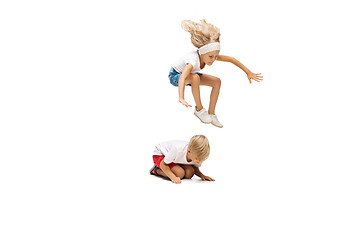 Image showing Happy little caucasian girl and boy jumping and running isolated on white background