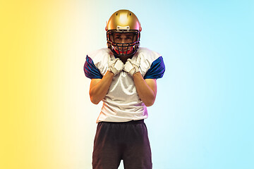 Image showing American football player isolated on gradient studio background in neon light