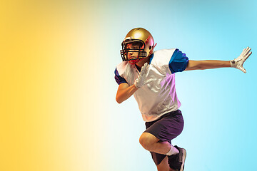 Image showing American football player isolated on gradient studio background in neon light