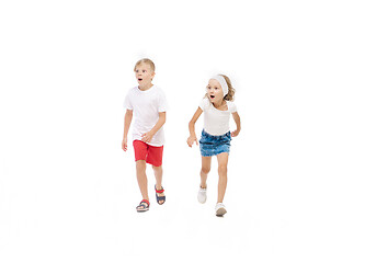 Image showing Happy little caucasian girl and boy jumping and running isolated on white background