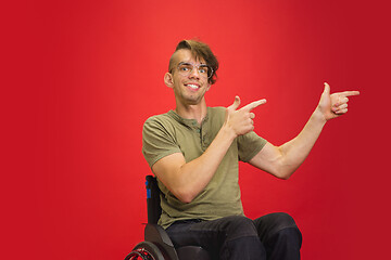 Image showing Caucasian young man\'s portrait isolated on red studio background. Human emotions concept