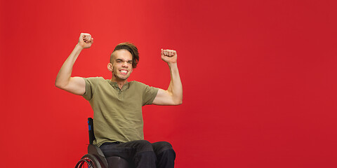 Image showing Caucasian young man\'s portrait isolated on red studio background. Human emotions concept