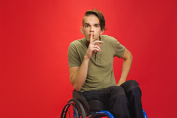 Image showing Caucasian young man\'s portrait isolated on red studio background. Human emotions concept