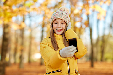 Image showing girl taking selfie by smartphone at autumn park