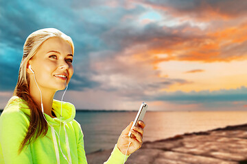 Image showing woman listening to music on smartphone at seaside