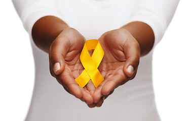 Image showing hands holding yellow gold cancer awareness ribbon