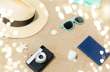 Image showing camera, passport, sunglasses and hat on beach sand