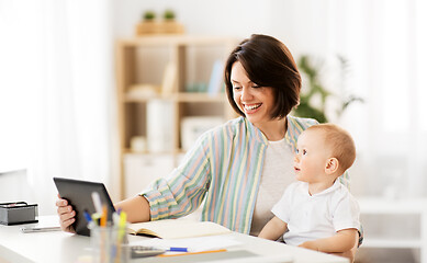 Image showing working mother with tablet pc and baby at home