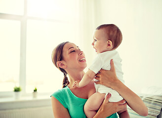 Image showing happy young mother with little baby at home