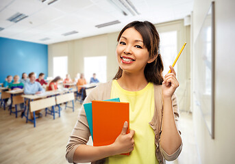 Image showing asian female teacher with books at school