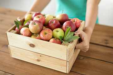 Image showing woman with wooden box of ripe apples