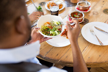 Image showing african america man eating salad at restaurant