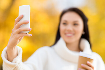 Image showing woman taking selfie by smartphone in autumn park