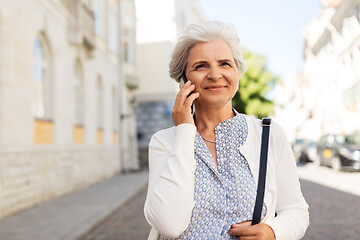 Image showing senior woman calling on smartphone in city